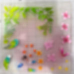 Colorful botanical and bird stamps on a clear grid plate, with green leaves, pink flowers, and small birds over a pink-tinted background.