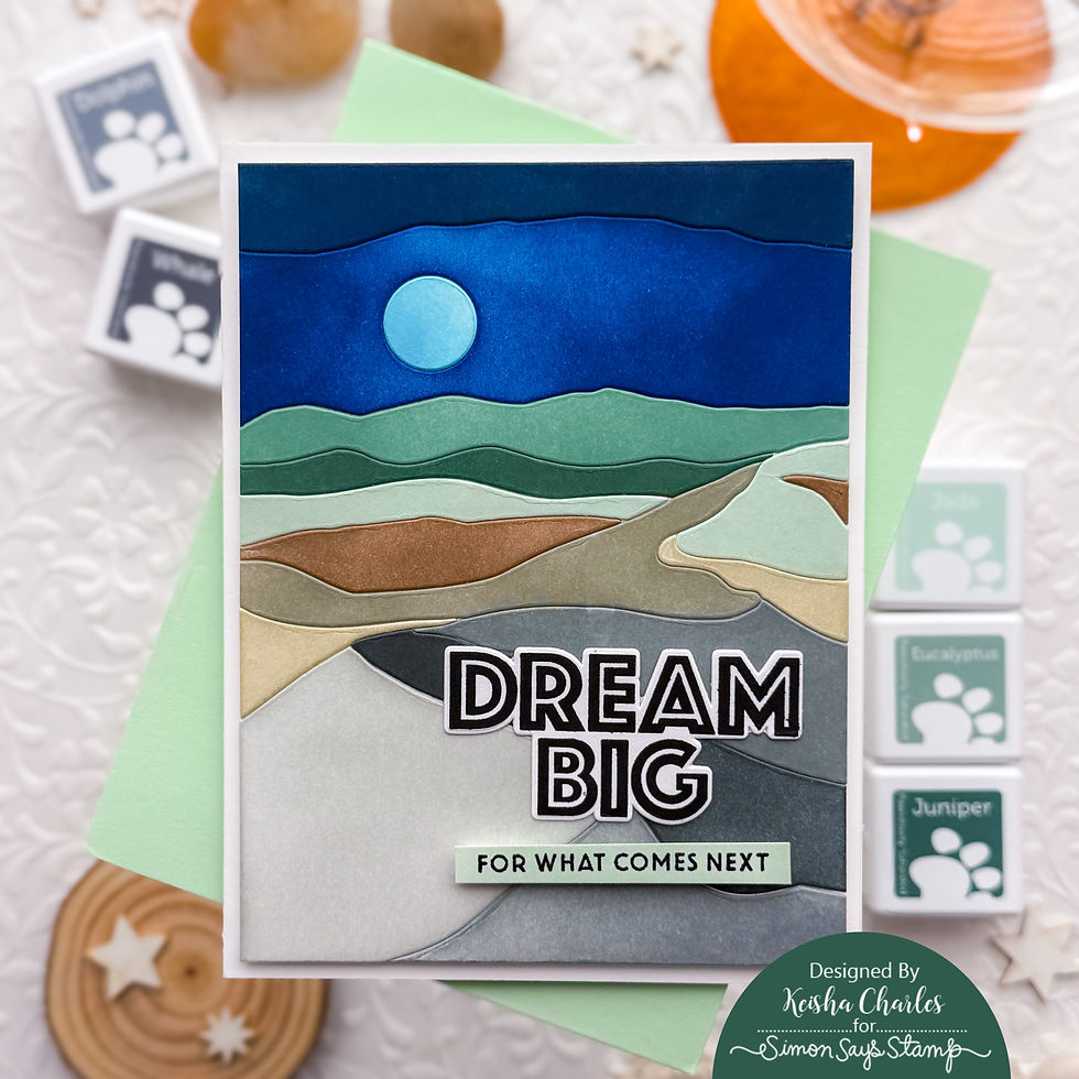 Layered landscape greeting card with blue moon and hills, reading DREAM BIG and FOR WHAT COMES NEXT, on a craft table.