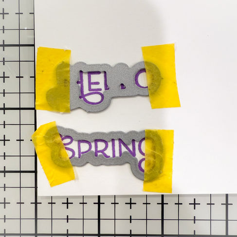 stamped sentiments with matching dies placed over them for die-cutting