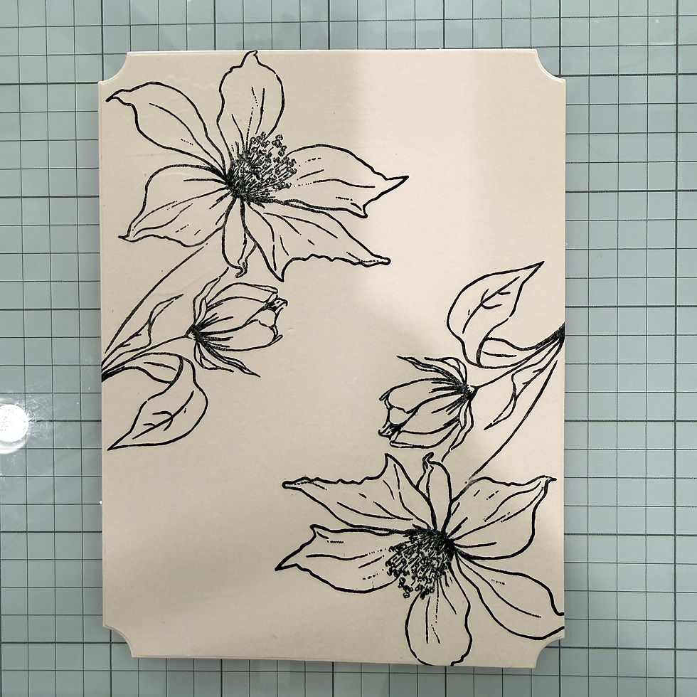 Cream panel with black line-art flowers and leaves on a blue grid cutting mat, a calm floral sketch.