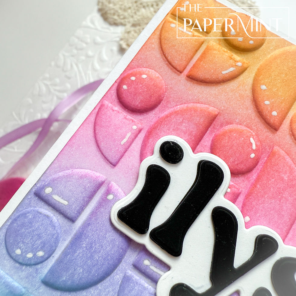 Colorful embossed card with geometric shapes in pink, orange, and purple hues. Black text partially visible. "The Papermint" logo in white.