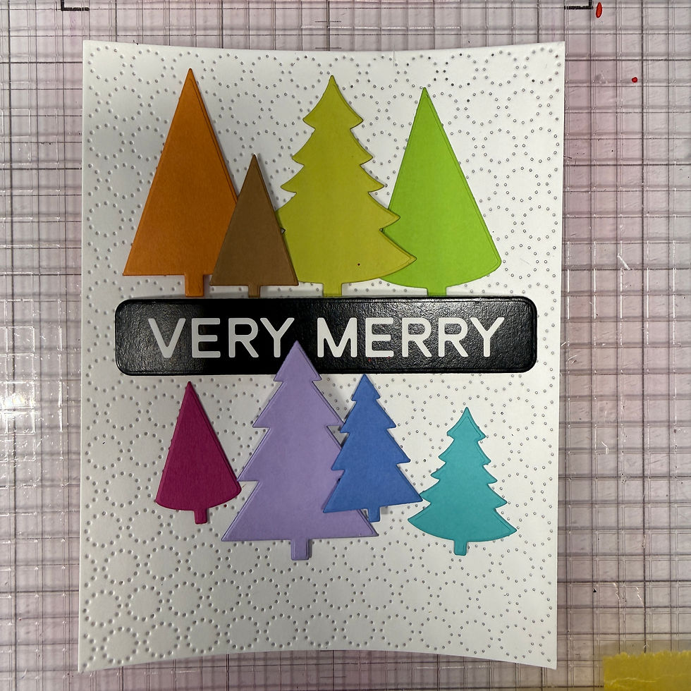Eight colorful die-cut trees arranged around a black VERY MERRY sentiment on a white pinpoint-circle panel, before adding the bow and stars.