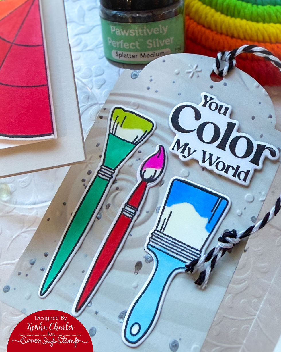 Colorful paintbrushes and the text "You Color My World" on a decorated tag. Background includes silver splatter and embossed patterns.