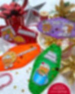 Festive gift tags with gingerbread designs and text like "Sugar and Spice" on colorful backgrounds, beside a red-striped gift box.