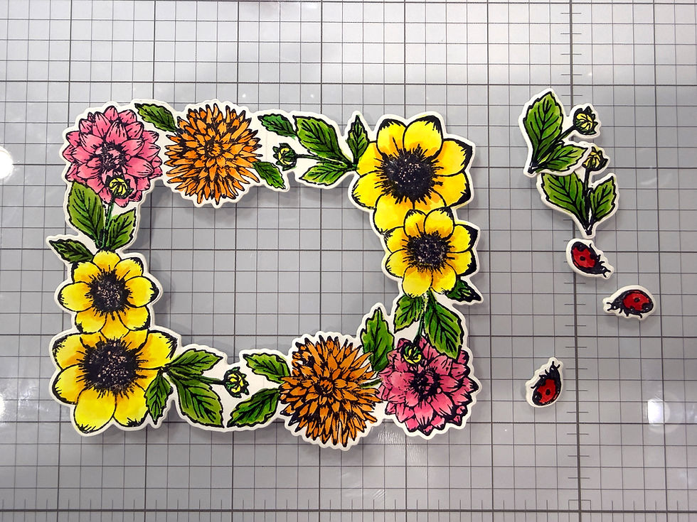 Colorful flower stickers arranged in a square frame on graph paper, with three red ladybugs on the right.