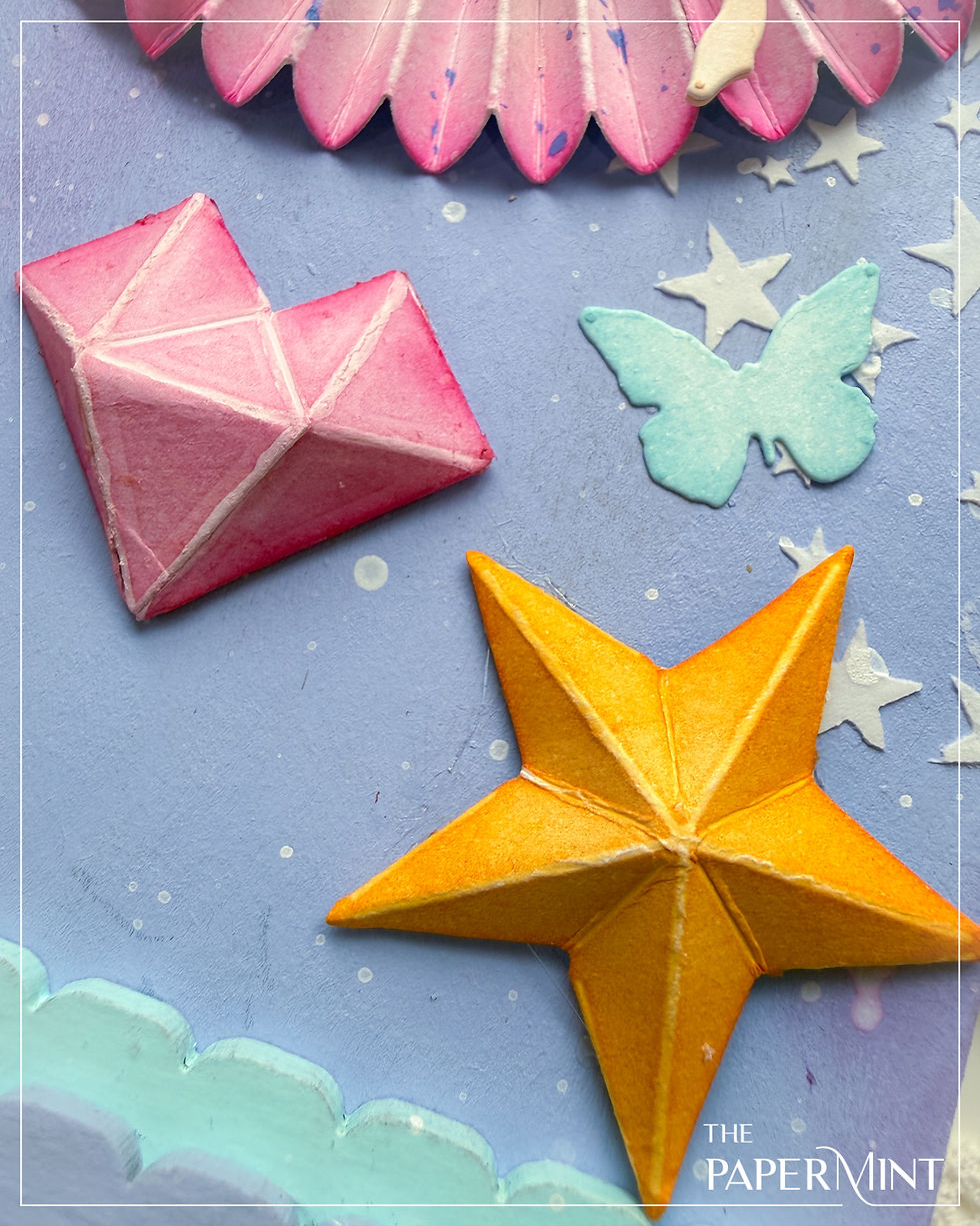 Pink heart, orange star, and blue butterfly shapes on a light blue background with stars. "The Papermint" text in the corner. Whimsical mood.