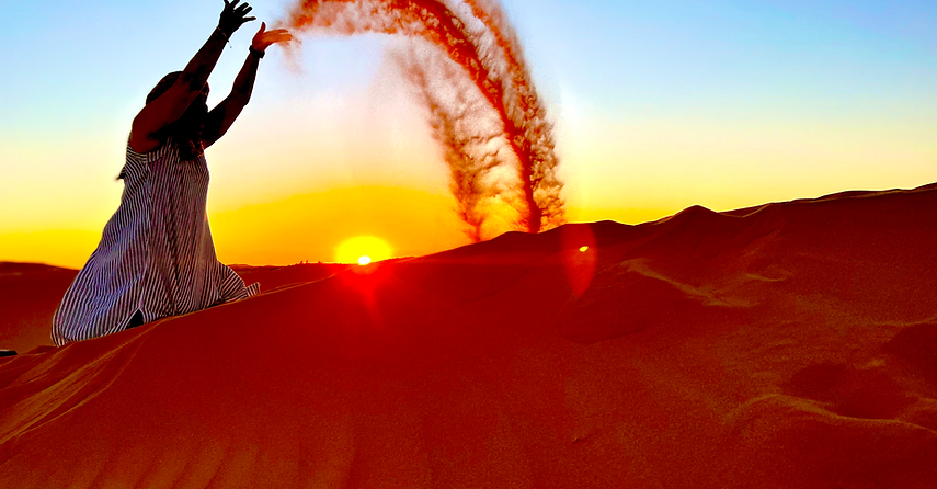 Sabi throwing sand in the air in sahara Morocco Retreat, October 23–31, 2025 – Soul Awakening wellness retreat with SOMA Breath® breathwork in Morocco
