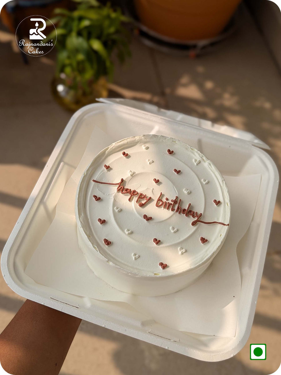Minimalist Korean white birthday bento cake decorated with tiny piped chocolate hearts by Rajnandani Cakes Pune.