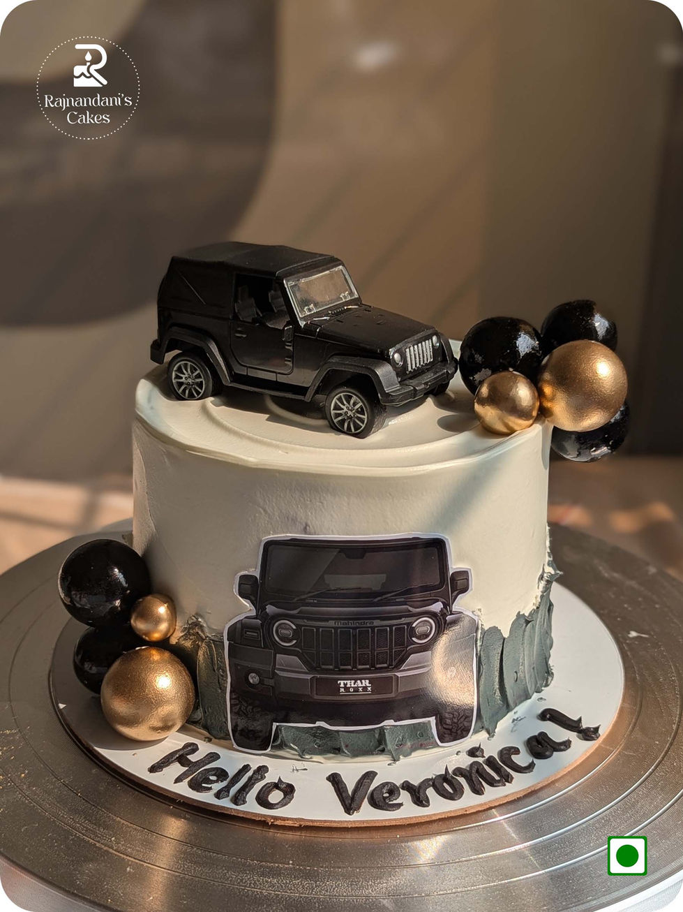 Custom Mahindra Thar off-road vehicle cake with black and gold spheres by Rajnandani's Cakes.