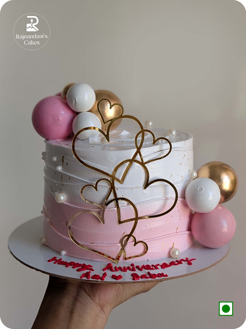 Blush pink ombre cake decorated with lustrous spheres, delicate pearls, and acrylic hearts by Rajnandani's Cakes.