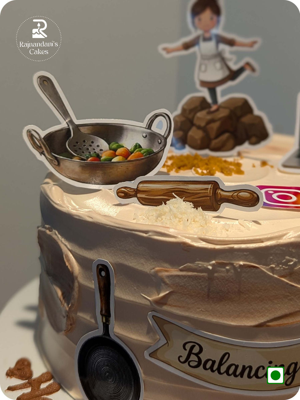 Custom balancing act theme birthday cake representing woman with kitchen tools and laptop cutouts by Rajnandani's Cakes.