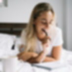 A woman sitting in bed journaling thoughtfully, reflecting self-exploration and sexual self-awareness often supported in Psychologist/Therapist, Relationship Therapy, and Couples Therapy work in Orange County.