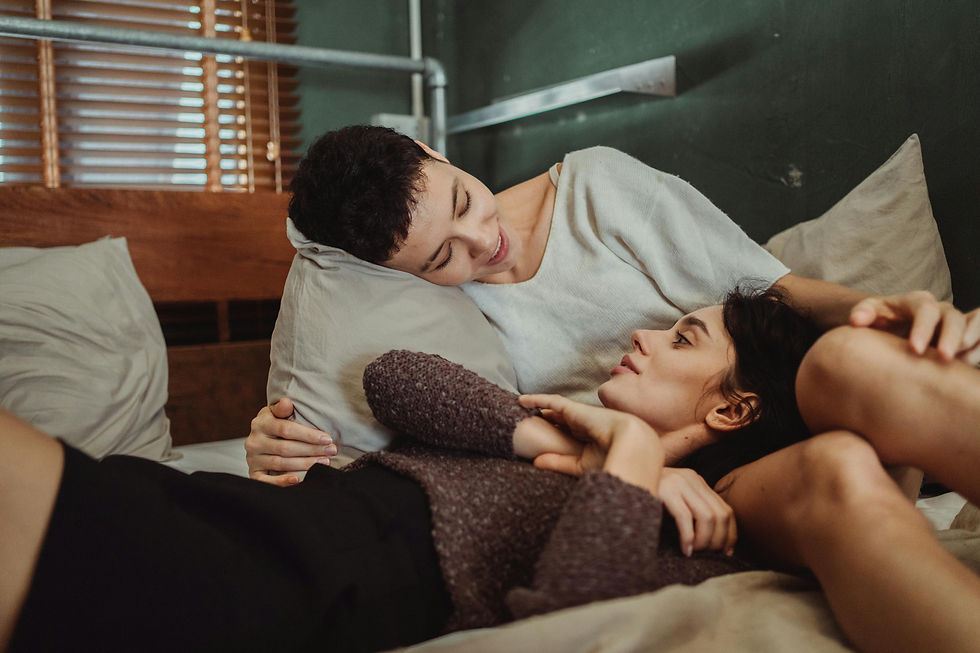 A lesbian couple talks sweetly in bed after intimacy, reflecting on the role of sex in their relationship with guidance from a Psychologist in Orange County offering Relationship Therapy and Couples Therapy.