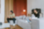A couple sits apart in their living room, the man focused on video games while his partner looks hurt, illustrating emotional disconnection discussed by a Therapist in Orange County specializing in Relationship Therapy.