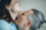 A man kisses his partner’s neck in bed, illustrating sexual arousal and emotional connection explored with a Psychologist in Orange County specializing in Relationship Therapy.