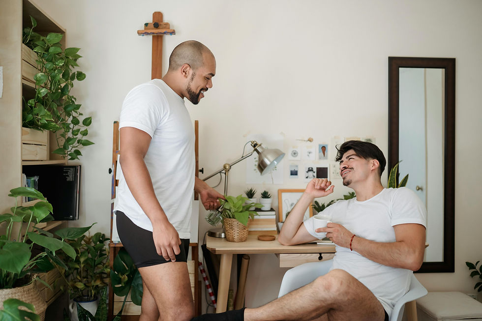 A gay couple talks in the kitchen after intimacy, exploring communication about needs and boundaries with support from a Psychologist in Orange County offering Relationship Therapy and Couples Therapy.