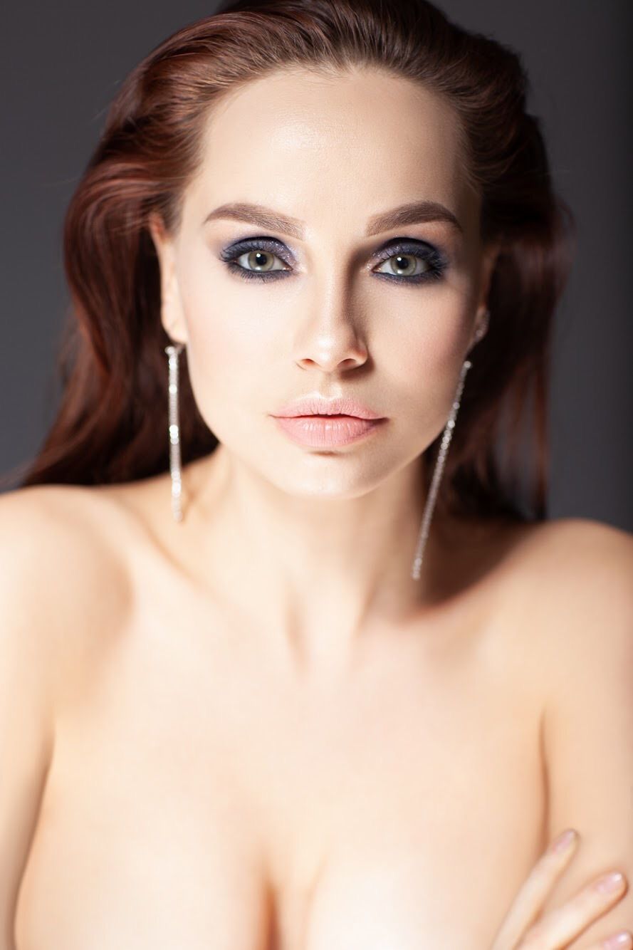 Close up beauty portrait with smokey eye makeup and long dangling earrings.
