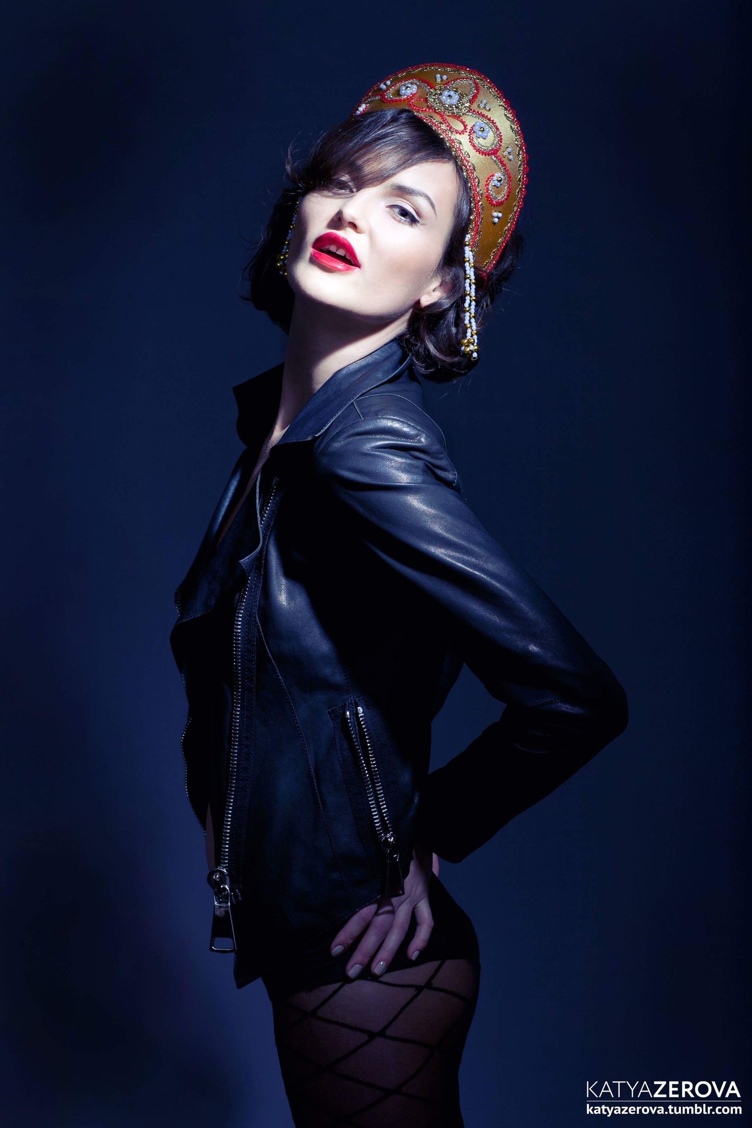 Retro-styled fashion portrait with leather jacket and patterned headscarf.