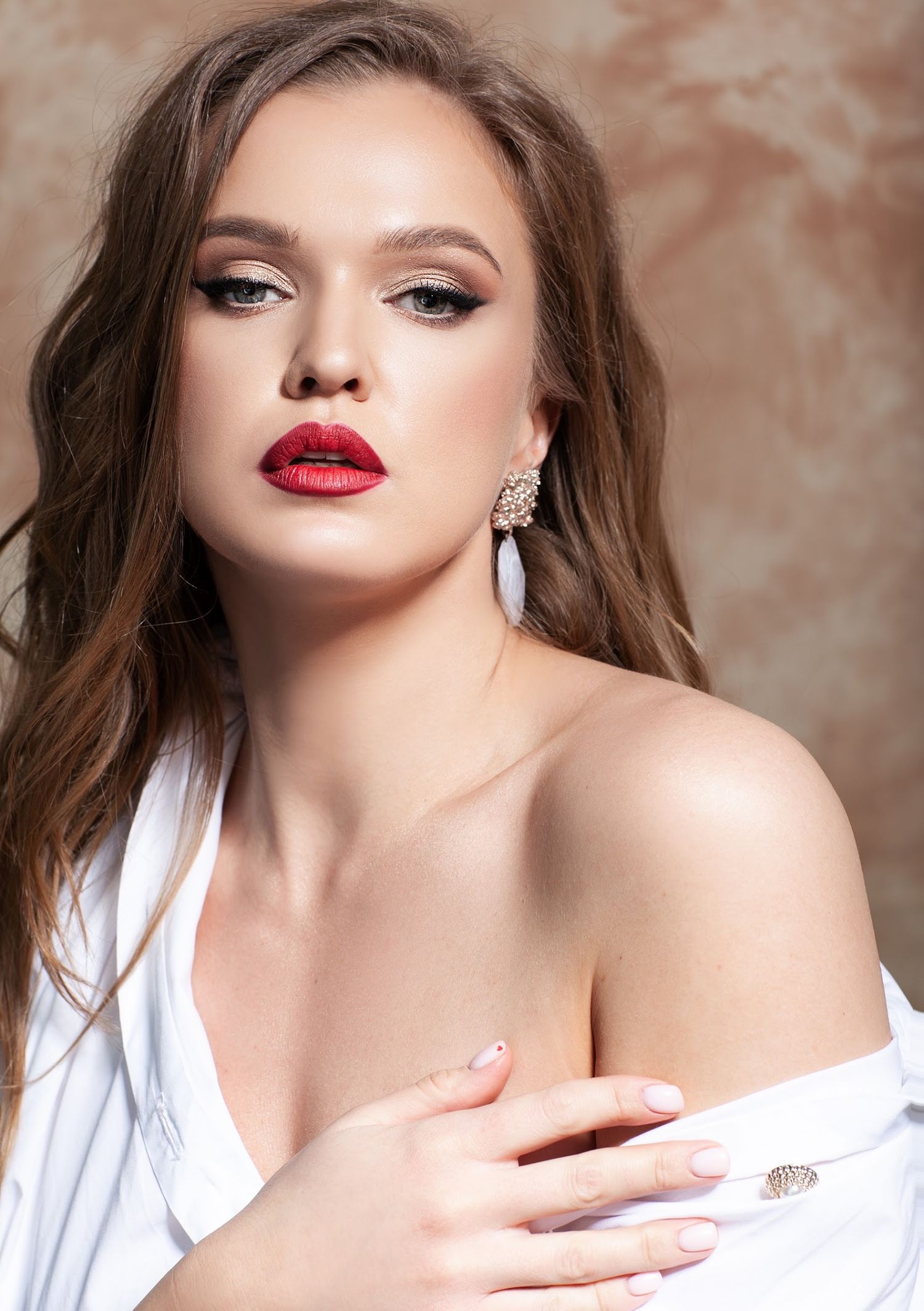 Glamour beauty portrait with red lipstick and dramatic makeup in white top.