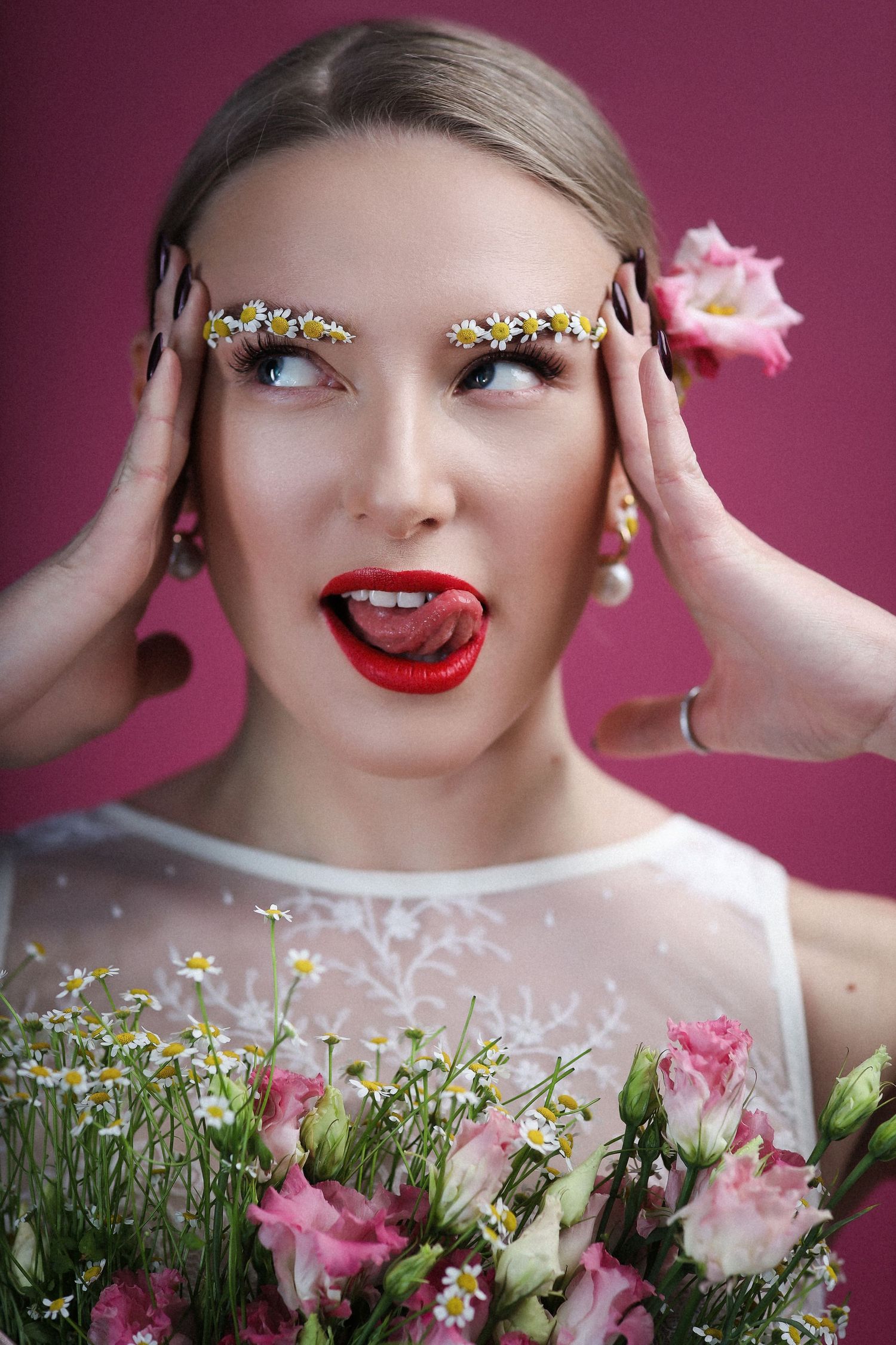 Artistic beauty shot with floral decorations and pink roses against burgundy backdrop.