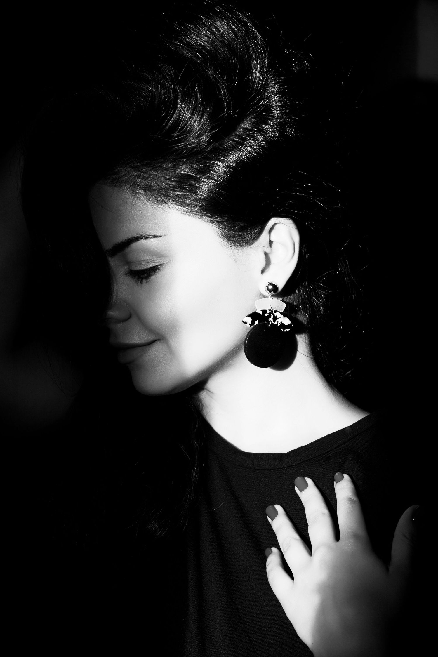 Black and white profile portrait showing elegant earring and emotional expression.