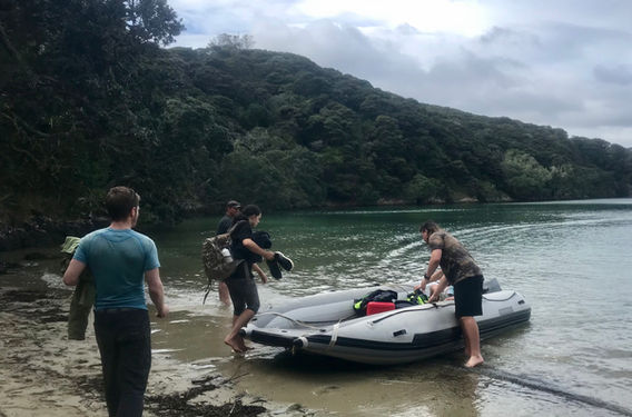 A group of individuals boarding the powerful T420LX safety boat on a beach.