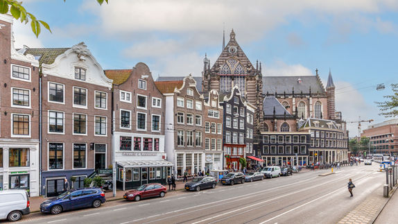 Straatbeeld van klassieke grachtenpanden en de Oude Kerk in Amsterdam, vastgelegd door RE-Framed