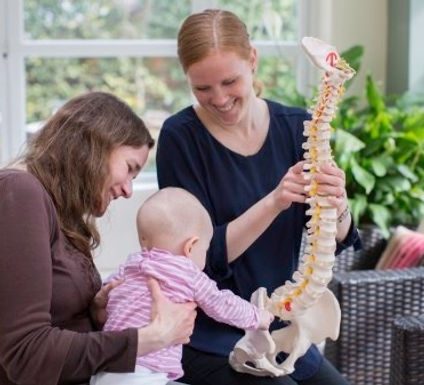 bishops waltham chiropractor explaining treatment to a patient and her child