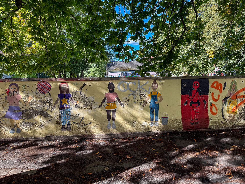 Gul mur med veggmaleri av lekende barn i Oslo