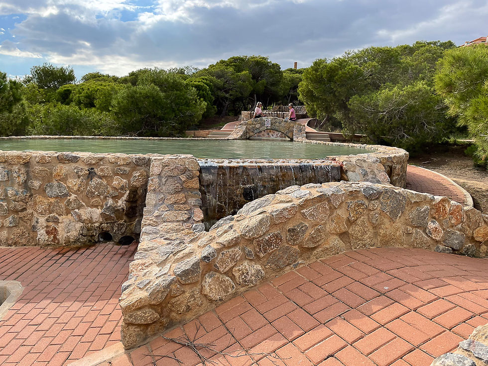 To kvinner ved kunstig anlagt dam og vannfall i Parque del Molino del Agua ved Playa de la Mata i Torrevieja