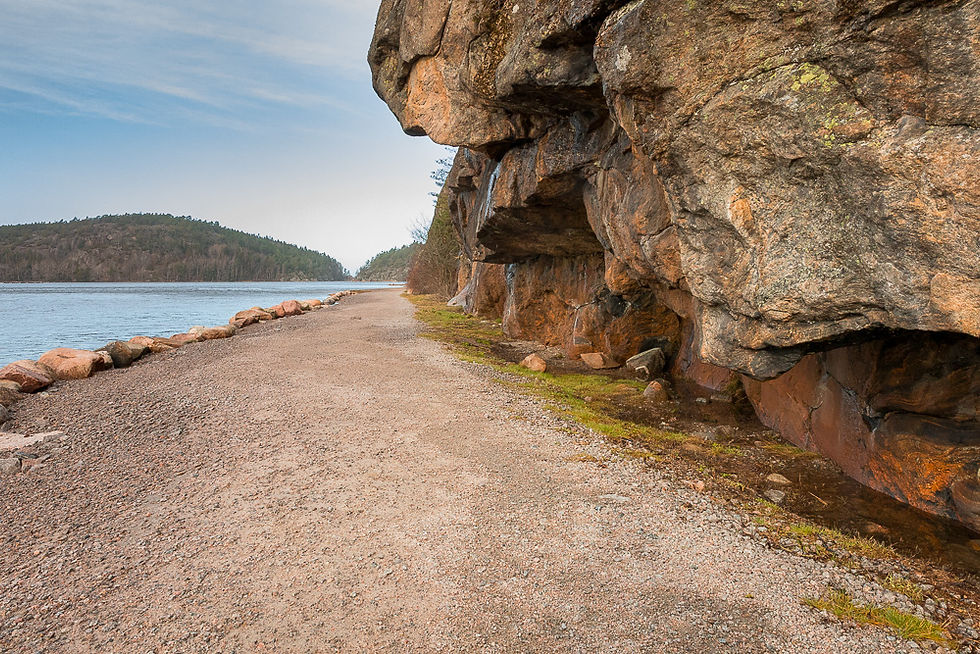 Rødfarget berg med overheng ved stranden i Daftö Resort ved Strömstad