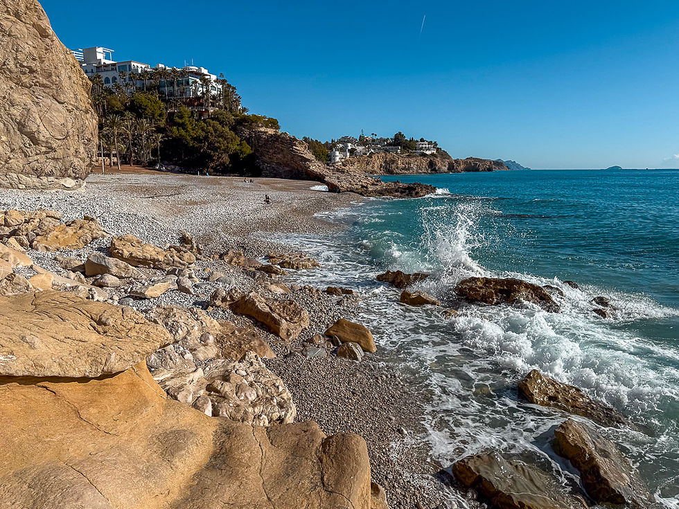 Nærbilde av strand med klipper Playa la Caleta i Villajoyosa på Costa Blanca