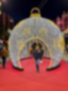 Kvinne kommer ut av lysdekorasjon formet som iglo om natten i Alicante i juletider