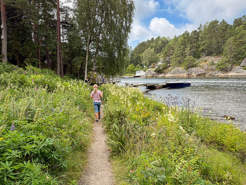 Kvinne går på sti i blomstereng ved stranden i Daftö Resort ved Strömstad