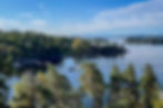 Båt i sund mellom øyer dette av skog i skjærgård