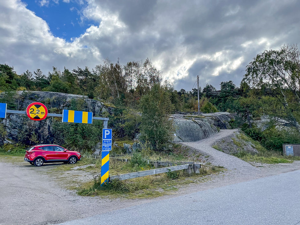 Rød bil parkert ved starten på turvei på Oljeberget i Strömstad