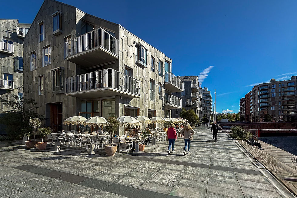 Havnepromenade med moderne bygg ved siden av med uterestauranter ved Sørenga i Oslo sentrum