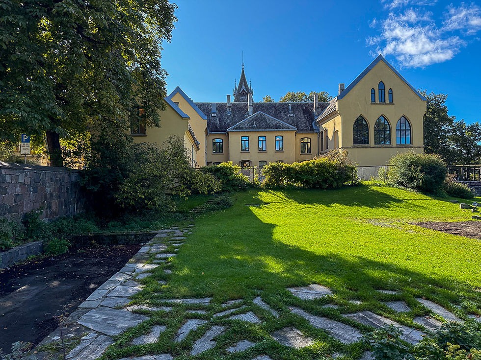 Store gule murbygg med portalformede vinduer og kirkespir ved Oslo Bispegård i Oslo