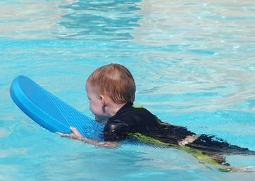 kleines kind mit schwimmhilfe