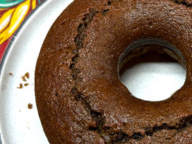 Bolo de beterraba em um prato branco e fundo de tecido de chita