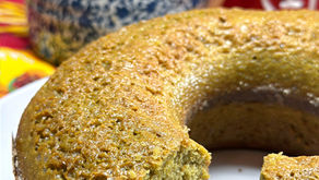 um prato branco de louça com um bolo de capim limão, chaleira estilo chinesa ao fundo