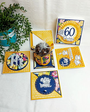 in der Mitte eine Kaffeetasse aus Papier, gefüllt mit Kaffeebohnen