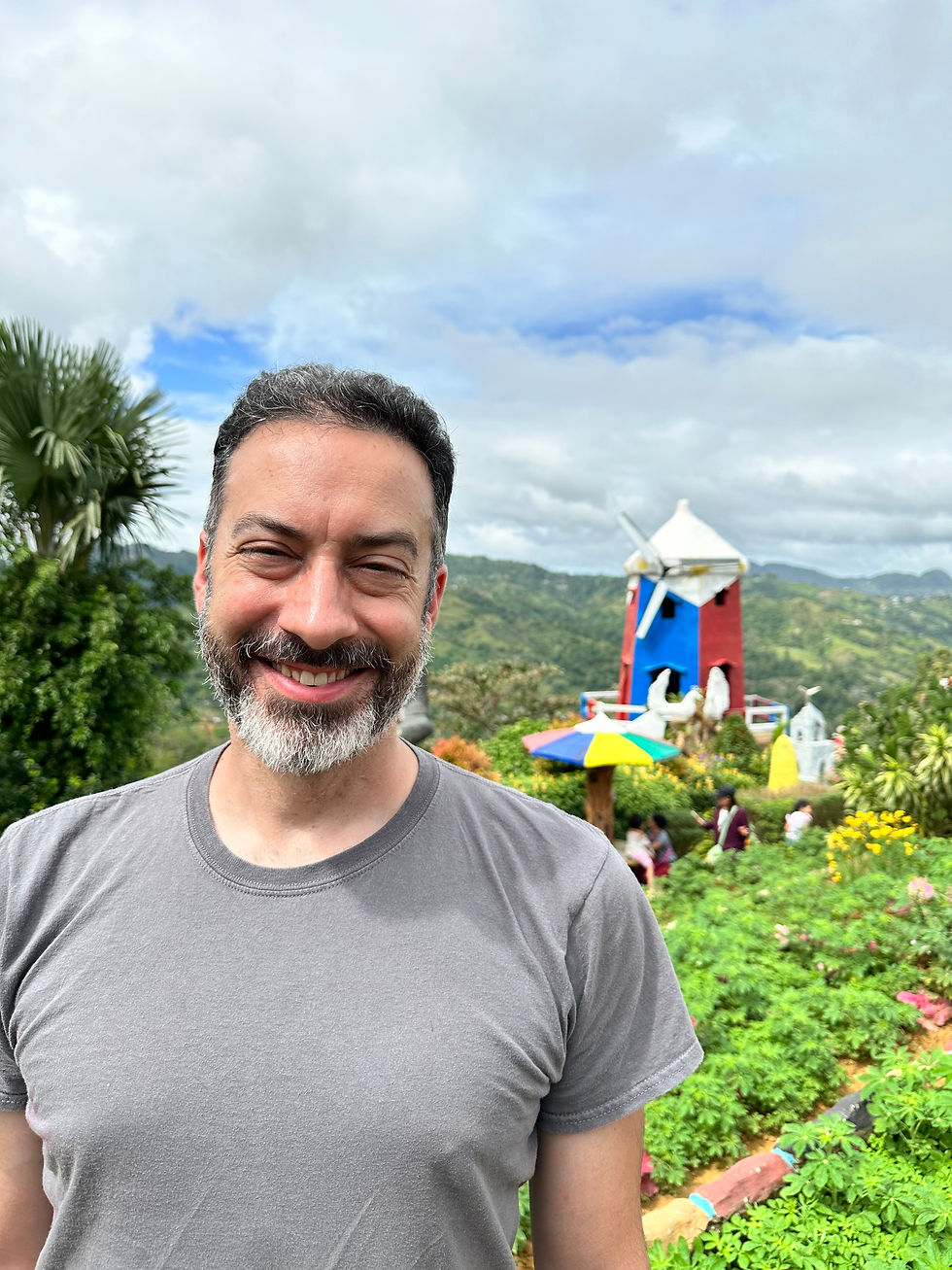 Kevin posing at one of the garden sites with a windmill