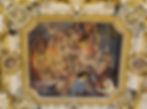 Ornate ceiling fresco depicting dynamic mythological figures amidst clouds, surrounded by intricate golden frames and decorative patterns.