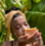 Woman smelling Rice, Shea Butter & Coconut soap with cream on her face outdoor.