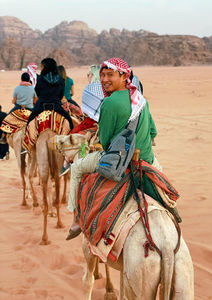Travelers on camels in a desert in Jordan