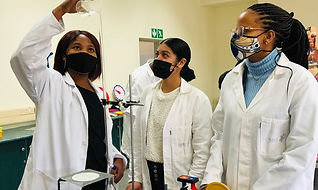 A beautiful young Science Capital SA, scientist performing a titration experiment under Physical Science- CAPS aligned with 2 matric Physical Science learners.