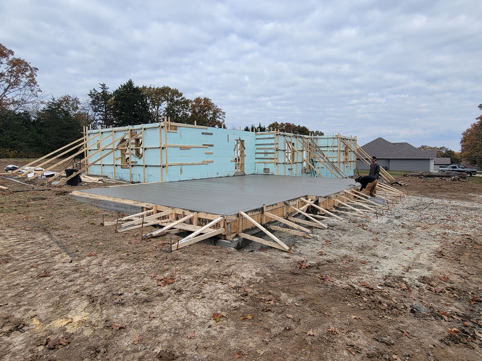 Construction site with concrete foundation and wooden supports.