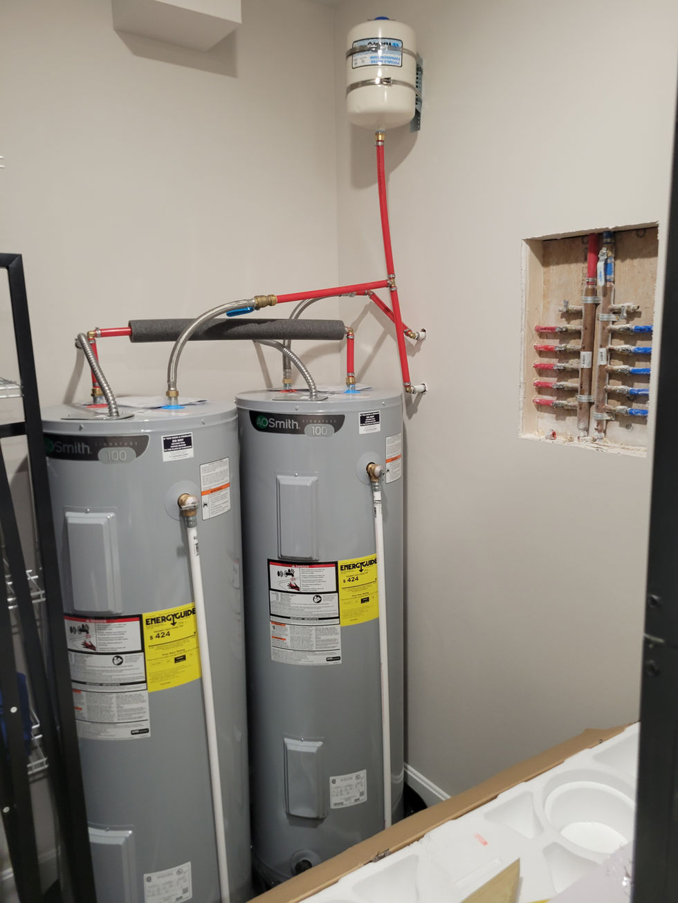 Two water heaters installed in a utility room.