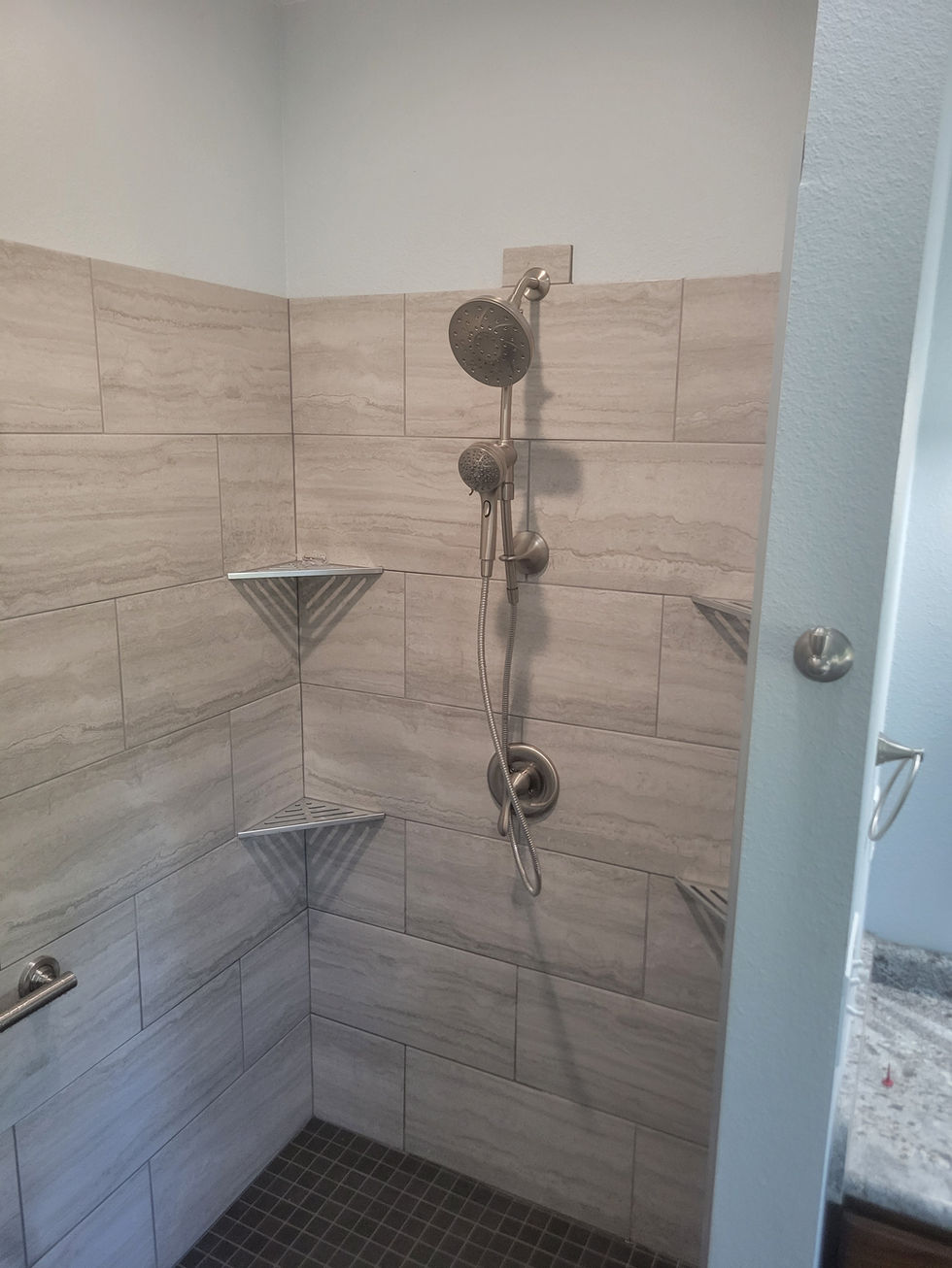 Shower with beige tiles and metal fixtures.